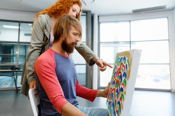 Young caucasian couple standing in a gallery and contemplating artwork