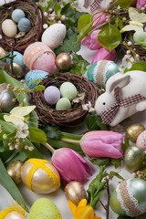 Assorted eggs and flowers for Easter on white