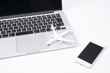 ノートパソコン、スマートフォンと飛行機模型
