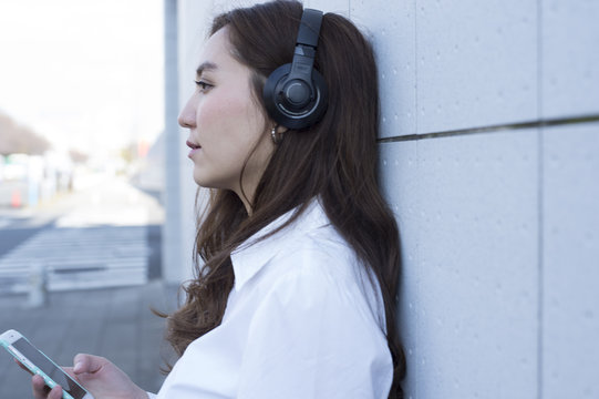 Young women are waiting for the people while listening to music