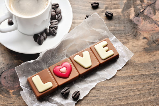 Fototapeta Chocolate bar  with letters Love and coffee on rustic background