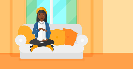 Pregnant woman sitting on sofa.