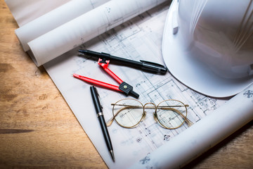 construction concept image helmet rolled blueprints on wooden bo