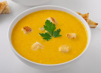 Pumpkin soup with croutons and parsley leaf
