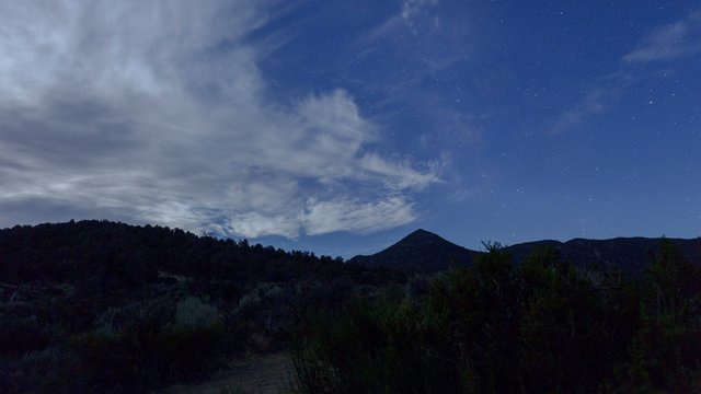 Wilderness Starscape - Night time lapse of stars and clouds moving over wilderness terrain. 