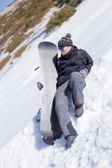 Fototapeta na wymiar Relaxed snowboarder with snowboard