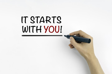 Hand with marker writing: It Starts With You!