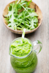Rucola smoothie, on the grey  background.
