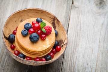 Stack of pancakes with blueberry and fresh berry.
