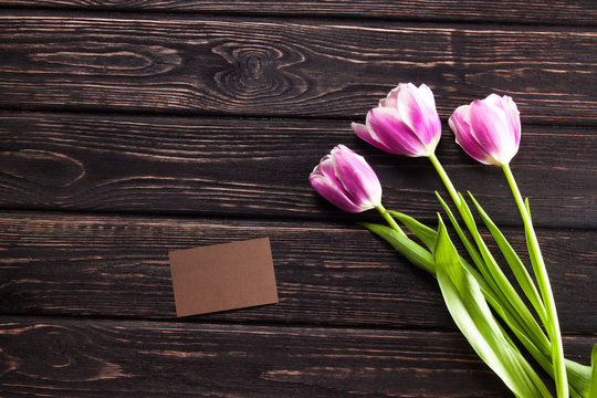 Tulips and a card on a wood