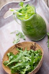 Rucola smoothie, on the grey  background.