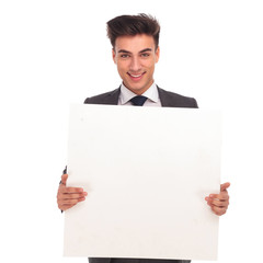 smiling young man holding a blank board