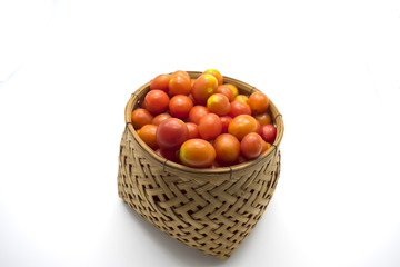 Cherry tomatoes in basket on white background