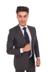 smiling young business man holding his jacket's collar