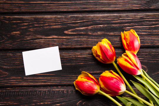 Tulips and a card on a wood