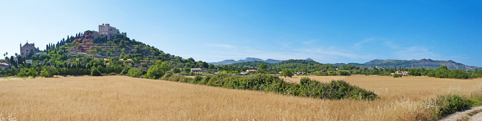 Fototapeta na wymiar Maiorca, isole Baleari, Spagna: la piccola città di Arta vista attraverso un campo di grano, 6 giugno 2012 