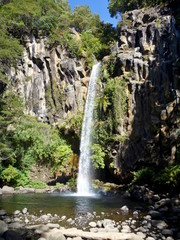 Fototapeta na wymiar small waterfall flowing of a basalt rock in a deep forest