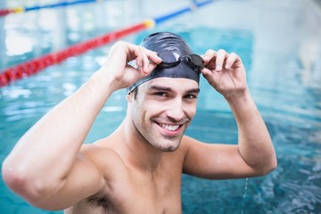 Handsome man wearing swim cap and goggles