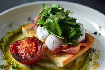 eggs benedict breakfast bacon poached egg, potatos and salad