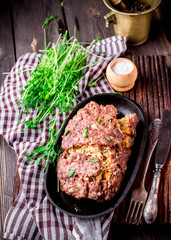 Homemade stuffed meat roll on iron pan.