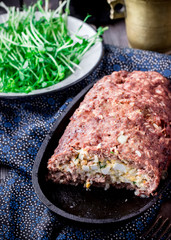 Homemade stuffed meat roll on iron pan.