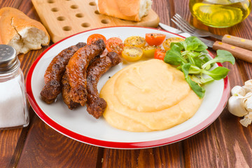Pure plate with sausage and salad on rustic wood