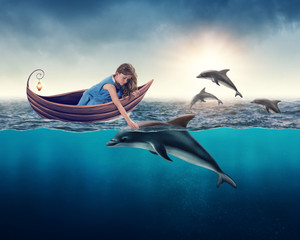 Naklejka premium Dziewczyna bawi się z delfinem