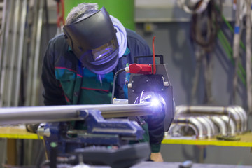 Industrial operator setting  computer controlled process of orbital welding machine in inox pipes...