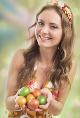 Woman is ready to Easter, holds multi-colored eggs in hand