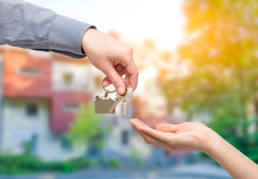 Man is handing a house key to a woman. Real estate concepts.