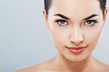 Obraz premium Lovely girl with dark hair at gray studio background