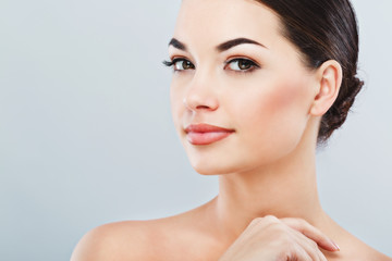 Pretty girl with dark hair at gray studio background