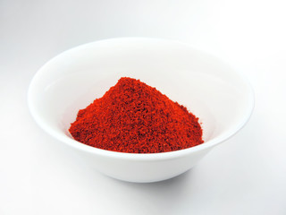 Dried paprika or red bell pepper spice in a white bowl