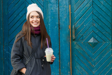 Pretty smiling girl, posing with cup of smoothie