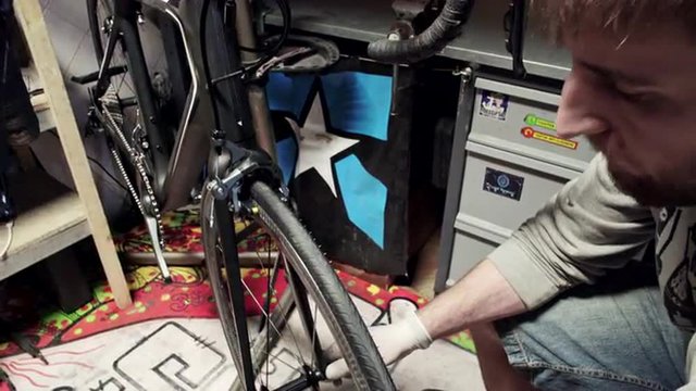 Mechanic repairing bicycle in workshop. Slider shoot