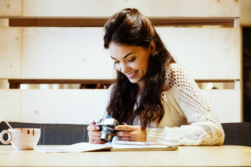 Charming woman sitting at the table with cup of coffee