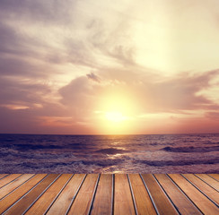 Fototapeta na wymiar Over sea setting sun with wooden floor 