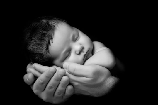 Father's love. Little newborn baby sleeping in Dad 's hands. Clo