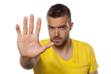 handsome young man showing stop hand