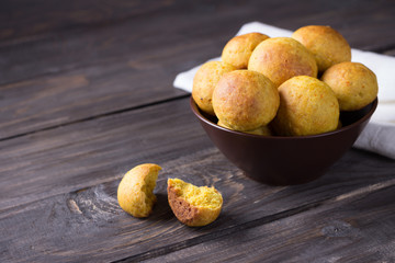 Vegetarian orange buns in ceramic bowl on wooden table