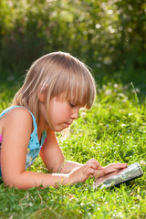 Child using a tablet computer outdoor