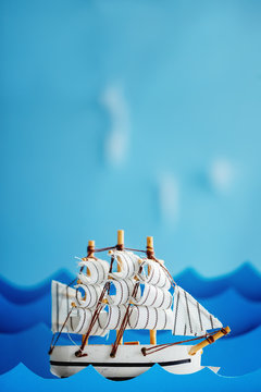 White Ship on blue wave with paper. Travel and adventure concept.