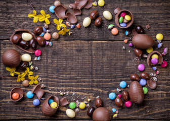 Chocolate easter eggs and sweets on wooden background