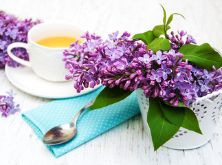 Cup of tea and lilac flowers