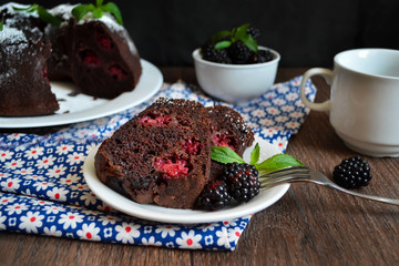 Chocolate brownie cake with blackberries sprinkled with powdered