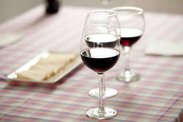 Glasses of red wine and cheese tray