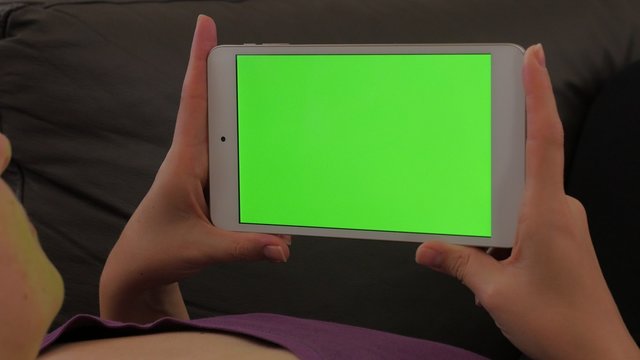 Woman holding silver tablet PC with green screen display in hands 4K 3840X2160 UHD footage - Looking to greescreen tablet display female 4K 2160p UHD video