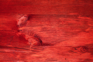 Red texture of wooden board with knots