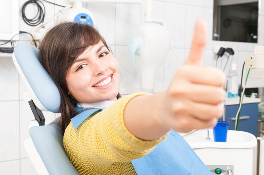 Smiling woman patient showing like in dentist office