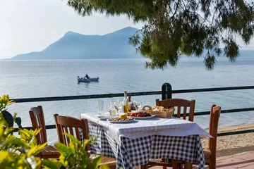 Wandaufkleber Lunch in a restaurant  near the sea © Santorines